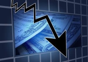 image of black downward arrow against a backdrop of money showing business losses