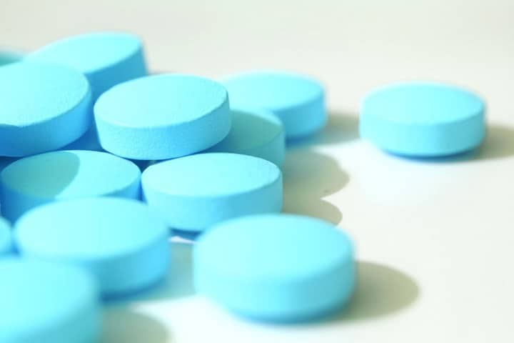 Close up of blue pills against white background