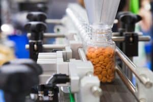 pharmaceutical industry, medicine pills are filling in the plastic bottle on production line machine conveyor at the medical factory SCAIR blog