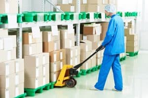 medical warehouse worker man loading boxes with medcine drugs by hand forklift