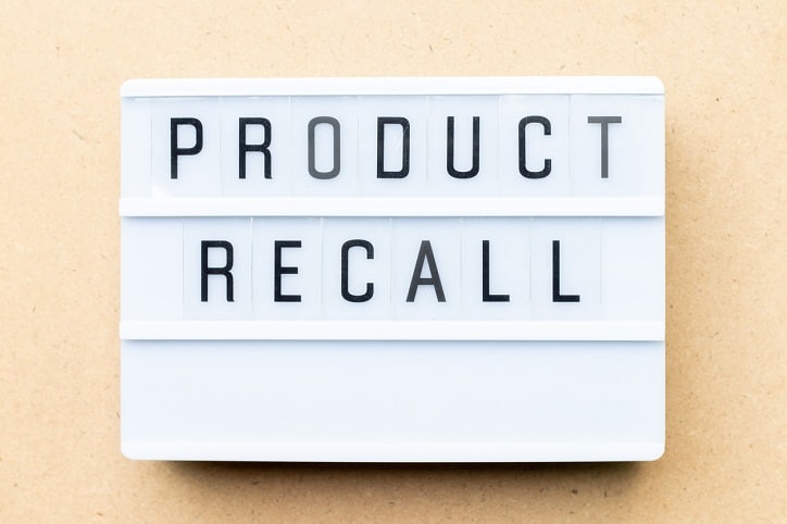 White lightbox with word product recall on wood background