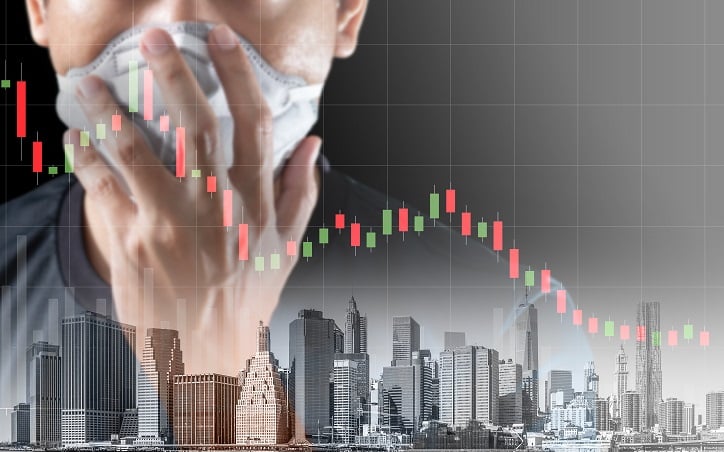 Close up of person wearing mask with city landscape and declining shares chart in background, representing business interruption insurance concerns in the wake of covid-19.