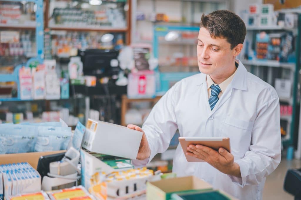 Pharmacist checking Checks Inventory of Medicine, Drugs, Vitamins with tablet and checking patient's prescription in pharmacy. Concept for SCAIR.