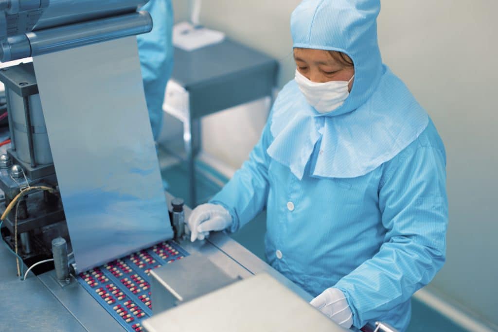 Chinese factory worker in assembly line producing pills